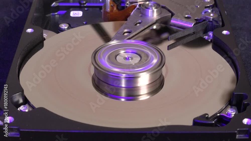Open hard drive, close-up view with colorful light effects, word STOLEN UN-written and starting to spin