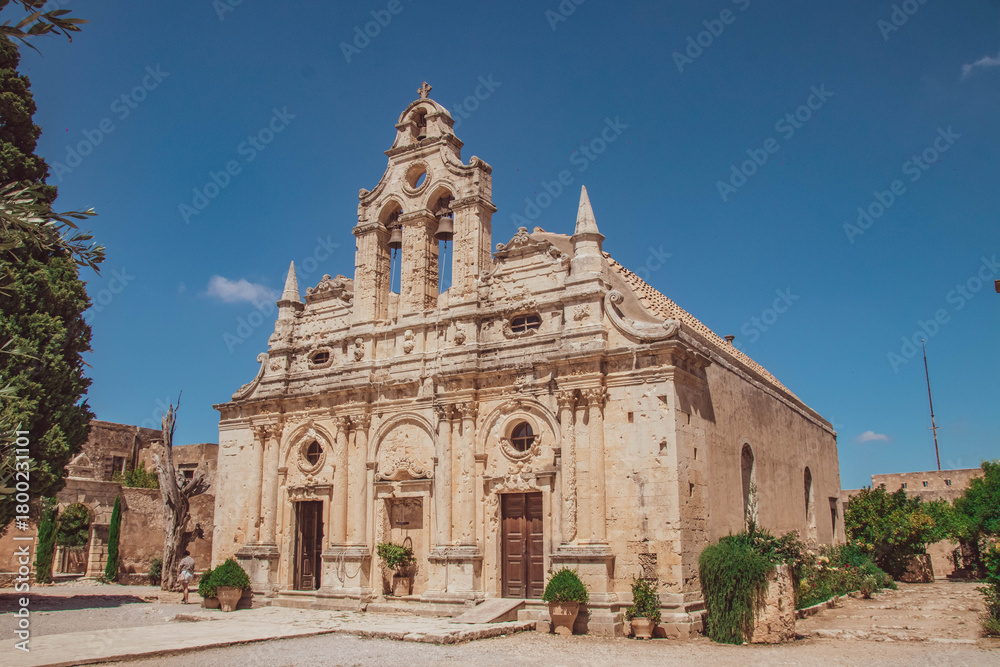 Fototapeta premium Historic facade of Arkadi Monastery with baroque details under a bright blue sky in Crete