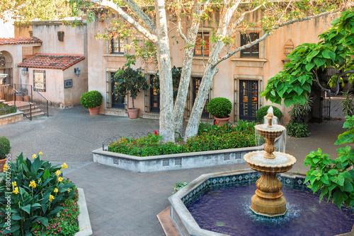 View of the North Courtyard with a fountain, large trees, shops, and art gallery buildings, at Mexican-styled Talaquepaque Arts Village, Sedona, AZ. USA.
