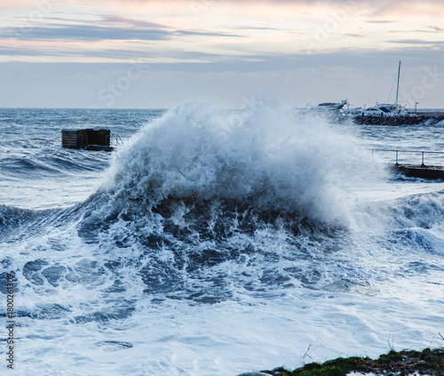 Powerful Ocean Wave Crashing Near a Harbour Pier