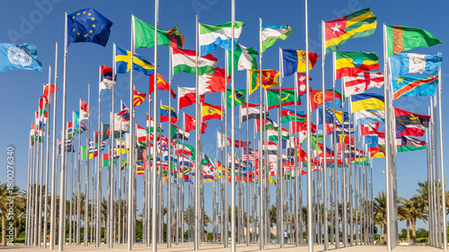 Many world's countries national flags waving on the wind, with United Nations, European Union, Bahrain, Ethiopia, Zambia, Sweden, Congo, Georgia banners in the foreground, Doha, Qatar