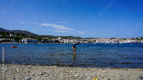 Woman walking into the Mediterranean Sea in Cadaques, Costa Brava, Catalonia, Spain