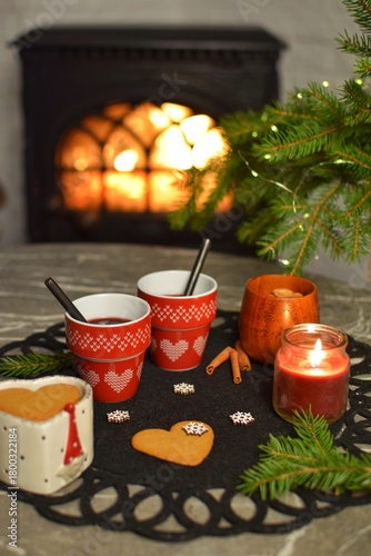 Two mugs of delicious mulled wine by the fireplace.