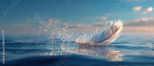 A single luminous feather drifts gracefully on the calm water as dawn breaks, surrounded by glimmering droplets