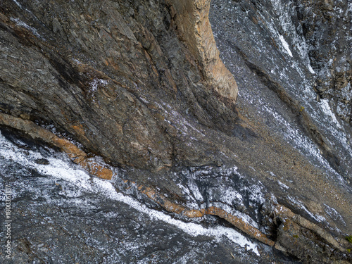 Rugged Rock Face With Snow Patches and Layered Cliff Formations in BC Canada