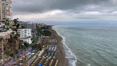 A sweeping seascape unfolds from the Sansuena Viewpoint in Torremolinos, Spain, where the tranquil blue horizon meets the rugged coastline in a breathtaking pan
