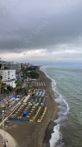 A sweeping seascape unfolds from the Sansuena Viewpoint in Torremolinos, Spain, where the tranquil blue horizon meets the rugged coastline in a breathtaking pan