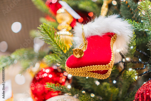 Wallpaper Mural Close-up of a decorated Christmas tree branch with a plush, detailed red boot ornament, surrounded by spherical red and gold ornaments Realistic style photography capturing intricate details under e Torontodigital.ca