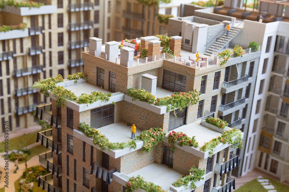 Obraz premium Model of a multi-storey residential building with plants on the terraces. Architecture