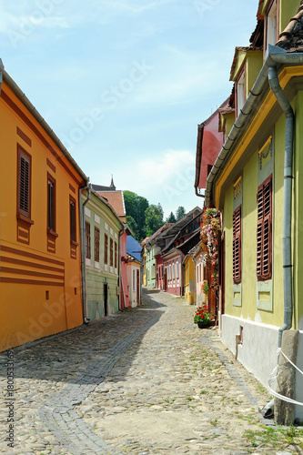Narrow street with colorful houses of old town of Sighisoara in Romania
