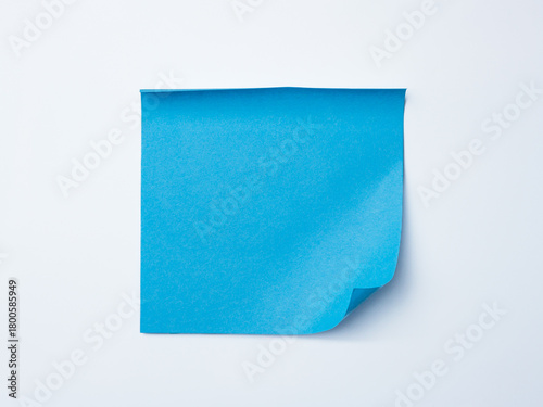 Single blue sticky note with curled corner placed on a clean white background.