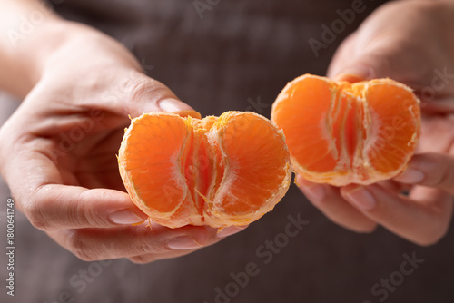 Mandarin orange fruit holding by hand and eating