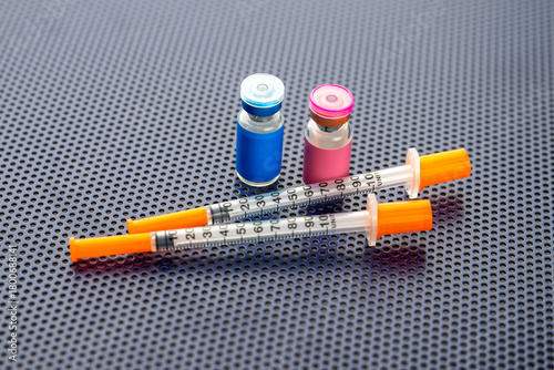 Single Use Syringes Next to Small Glass Vials