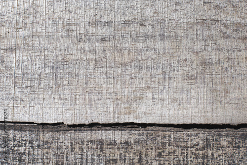 Rustic grey wood texture background with a prominent horizontal crack. Old timber surface showing natural wear and distressed detail.