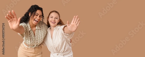 Happy young women on brown ...
