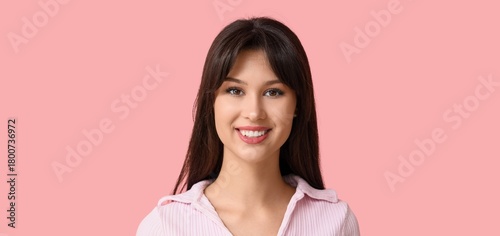 Smiling young woman on pink...