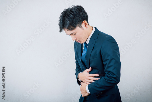 腹痛で体調不良の男性会社員
Male office worker feeling unwell due to stomach pain