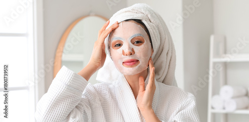 Young woman with sheet mask...