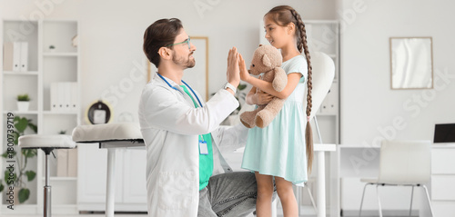 Male pediatrician giving hi...