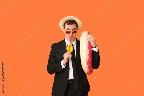 Office worker with inflatable ring and cocktail dreaming about vacation on or...