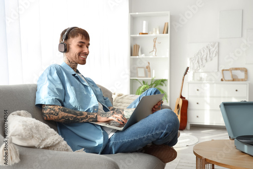 Young tattooed man in headp...