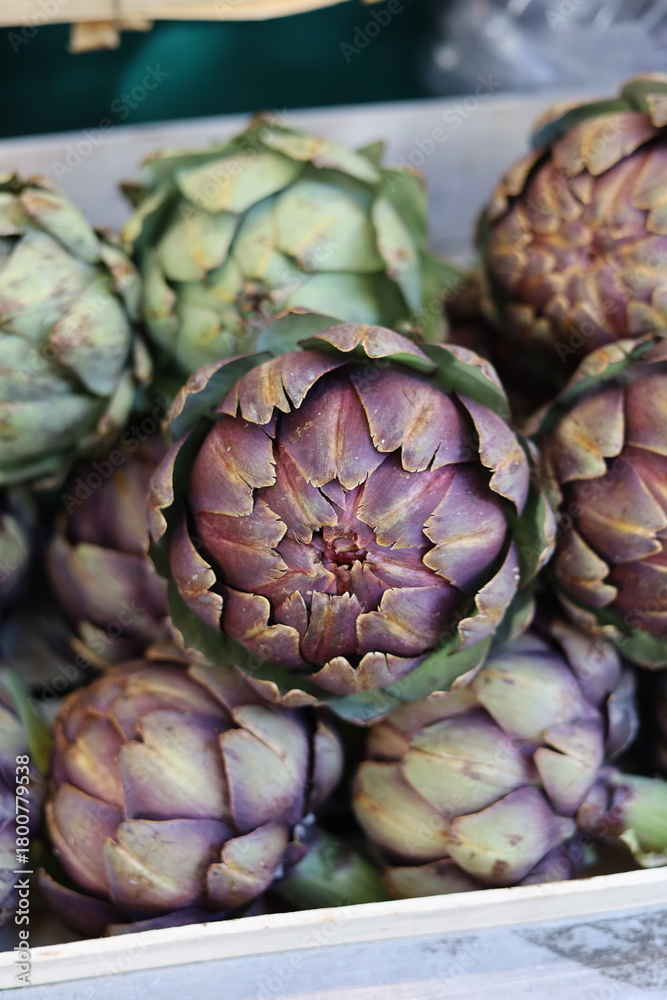 Obraz premium Fresh organic artichokes displayed for sale in produce market vertical photo