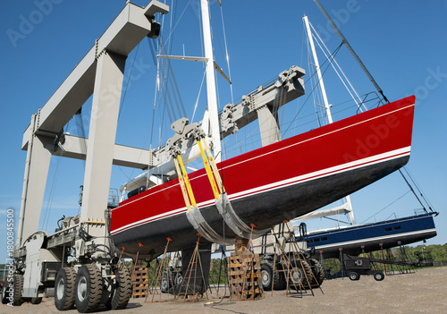 Large Boat Lift:  An industrial boat lift holds the hull of a large sailing yacht at a New England shipyard.
