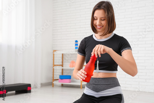 Sporty young woman opening ...