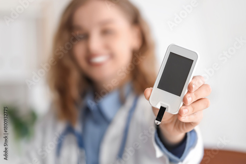 Female doctor with glucometer in office, closeup