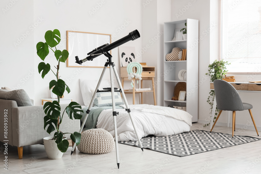 Fototapeta premium Interior of stylish children's room with bed, table and modern telescope