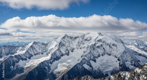 Majestic snowcapped mountain range under a dramatic cloudy sky, showcasing rugged peaks and glaciers