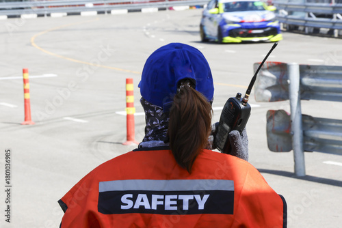 Photos Vigilant safety marshal staff official working car race, using radio for communication on racetrack