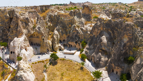 Wallpaper Mural Goreme, Nevsehir, Turkey. Overhead view of Goreme Open Air Museum with tourists exploring ancient cave entrances and rock-cut churches.. Aerial View Torontodigital.ca
