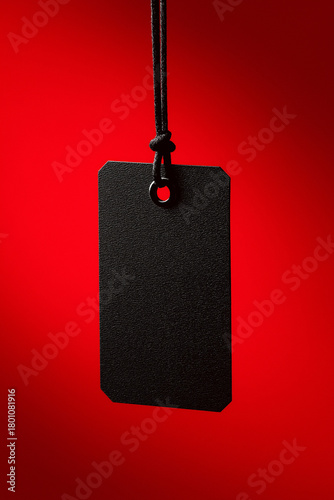 Black Blank Tag Hanging on Red Background for Branding or Sale Concept