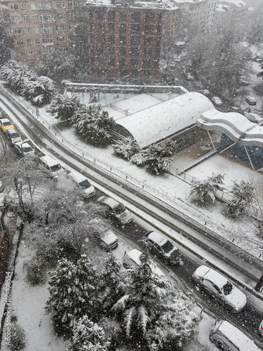 snow covered cars on road in city. Heavy snowfall over urban residential street