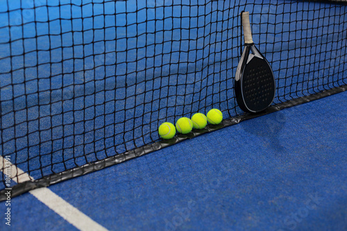 Net, balls and paddle racket on the blue court