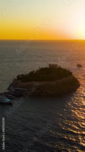 Vertical video. Kusadasi, Turkey. Historic Pigeon Island Fortress, once the base of Admiral Barbarossa, at sunset. Captures the iconic Pirate Castle. Aerial View. Rich colors