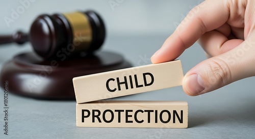 Child protection concept with wooden blocks and gavel on gray background