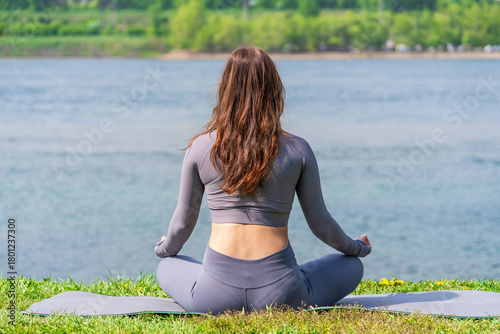 Fotografie Practicing yoga by the serene waterfront on a sunny day