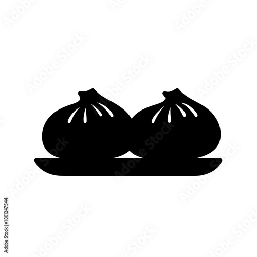 Two steamed dumplings on plate, traditional asian food