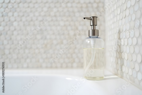 Clear soap dispenser on white textured surface with subtle lighting
