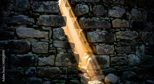 A narrow waterfall flowing between ancient stone walls illuminated by sunlight, creating a serene and mystical natural scene