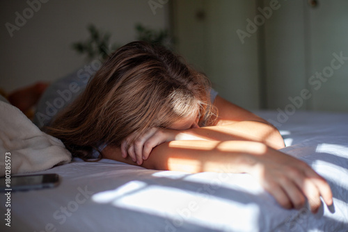 Teen Lying on Bed, Sad and Lonely with Phone Nearby