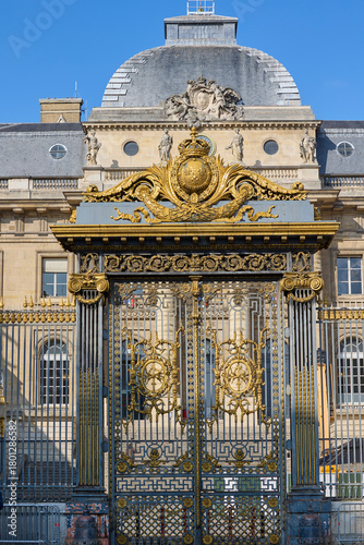 Ornate golden gates and facade of the Palais de Justice in Paris, France, showcasing classical architecture under a clear blue sky.