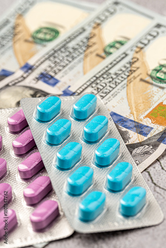 Dollar bill and a set of medicine pills. Rising costs of medical care. Reliefs for buying medicine.Pills in capsules scattered on US dollars currency.Concept of health care in USA.