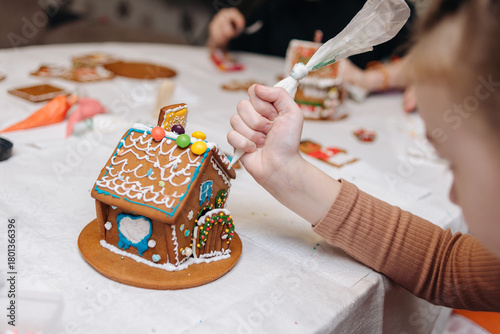 Children happily decorating gingerbread houses with icing and candy for a festive Christmas holiday activity