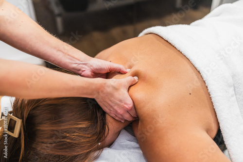 Obraz na plátně Woman receiving a therapeutic deep tissue massage on her shoulder, promoting rel