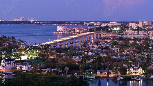 Aerial view of the bridge stretching over the tranquil water, connecting the vibrant cityscape under the pastel sky, St. Pete Beach, Florida, United States.