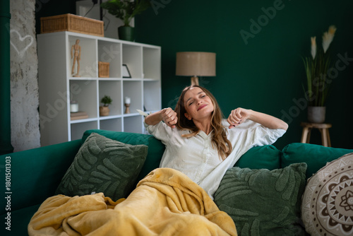 Fotografie Woman stretching on sofa at home living room