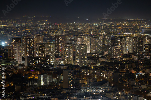 Aerial view of a cityscape bathed in a warm, dense glow of lights, illuminating the night in a mesmerizing display of urban energy, Paris, Ile-de-France, France.